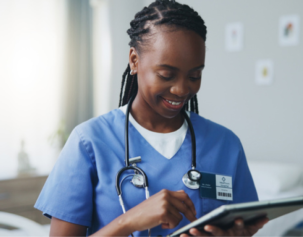 Doctor smiling and using a tablet