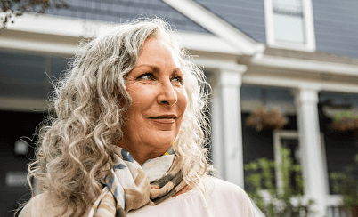 Woman outside of house smiling 